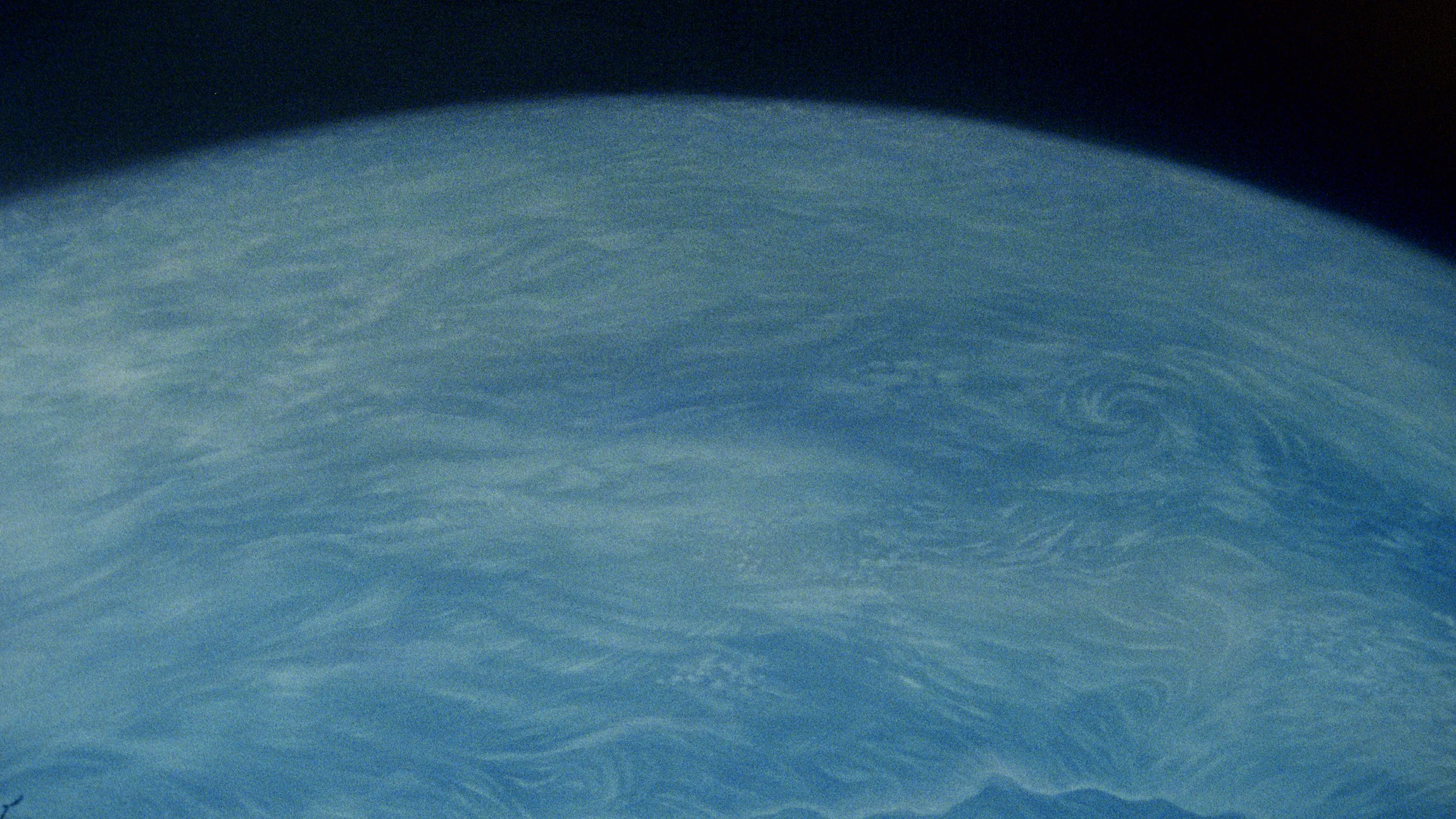 A grainy blue close view of the Moon